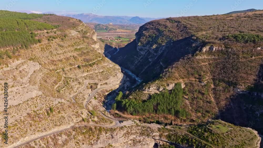 Serpentine road follows river bend in wild French gorge. Aerial drone video Serpentine road follows river bend in wild French gorge. Aerial drone video