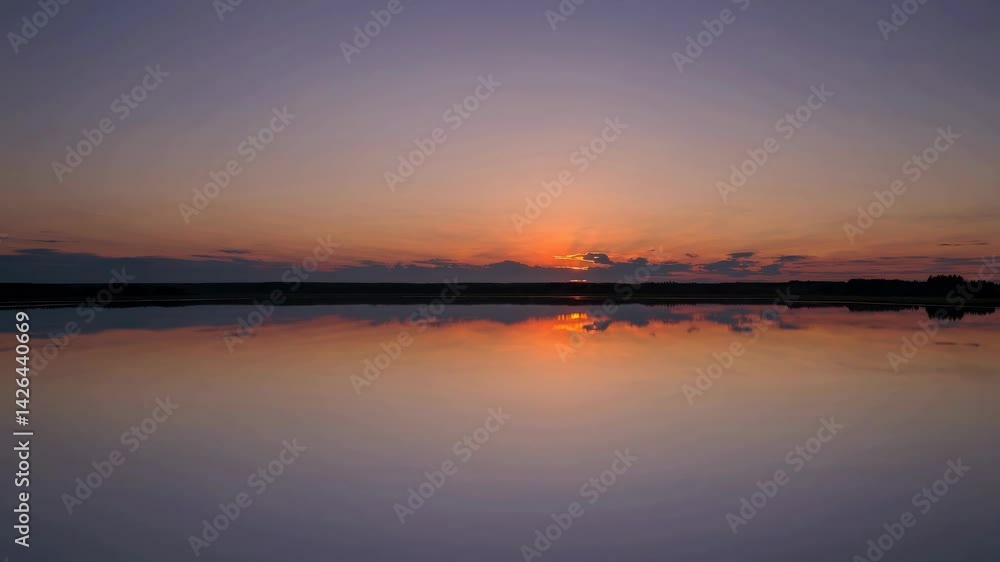 Tranquil lake sunset with vibrant orange reflections on still water Tranquil lake sunset with vibrant orange reflections on still water
