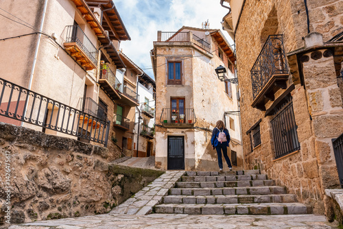 Tourist woman enjoying the old stone houses in the town of Beceite, Teruel.