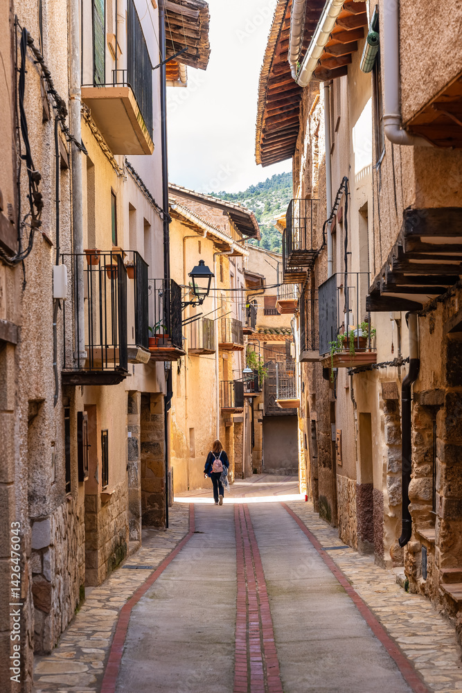 Tourist woman enjoying the old stone houses in the town of Beceite, Teruel.