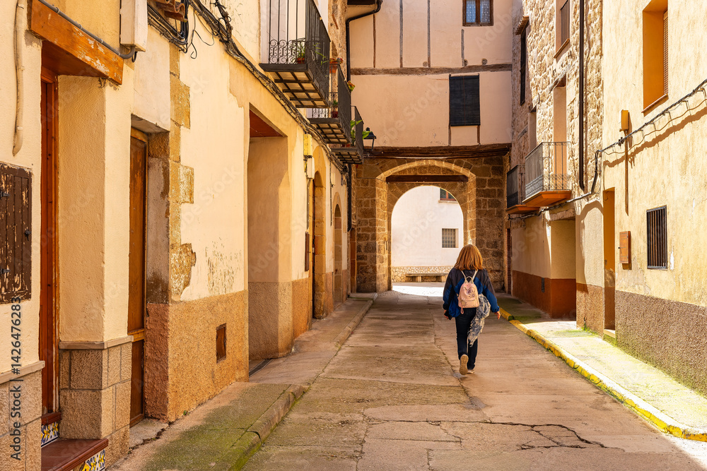 Tourist woman strolling through the picturesque streets of the beautiful medieval town of Beceite, Teruel.