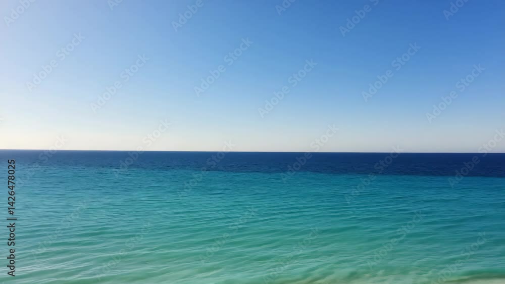 Pristine shoreline with gentle waves and clear water stretching into horizon, untouched and peaceful under bright daylight Pristine shoreline with gentle waves and clear water stretching into horizon, untouched and peaceful under bright daylight