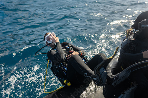 Scuba diver entering water with backward roll from inflatable boat