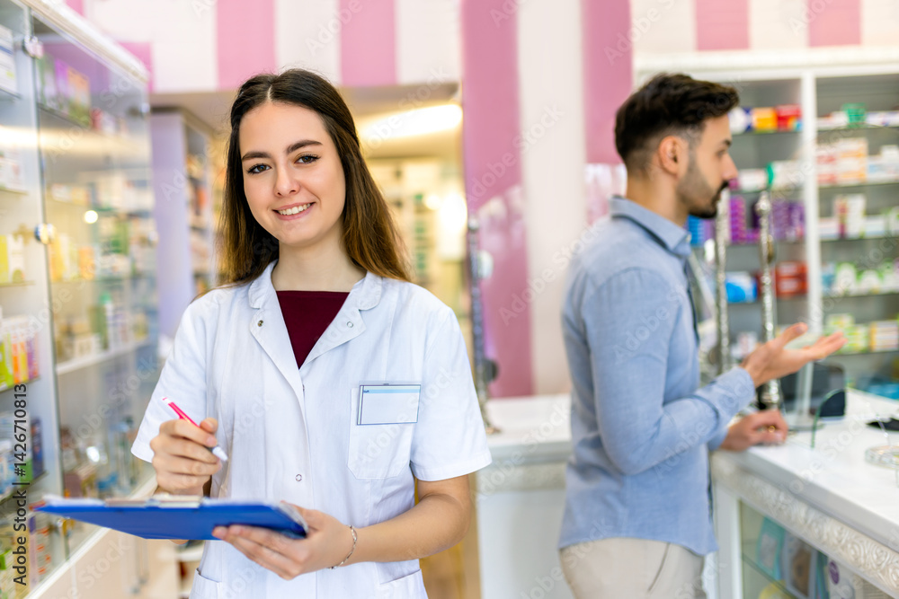 Obraz premium Portrait of professional smiling healthcare worker in the pharmacy store holding the checklist.