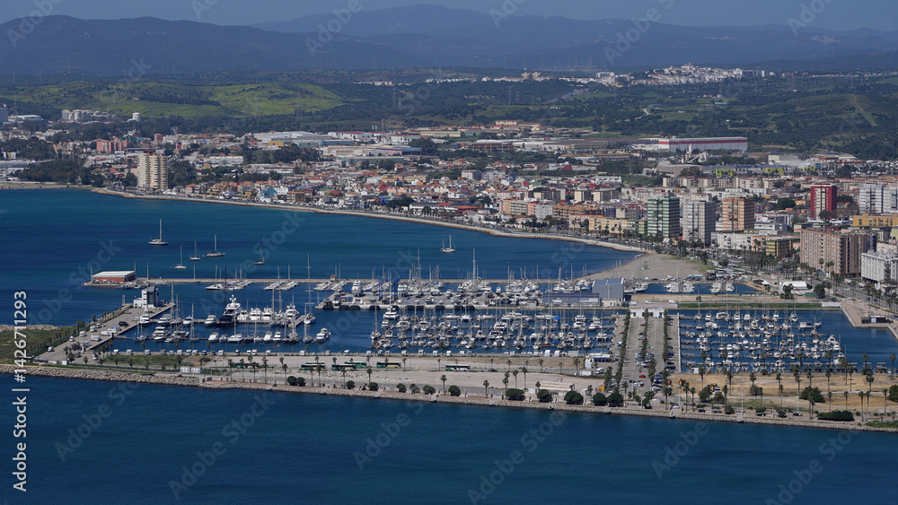 Obraz premium Many white boats mooring in marina with city and mountains in background - GIBRALTAR, UK - MARCH 31, 2025