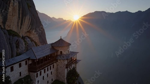 Sunrise illuminates Ostrog Monastery perched dramatically on a steep cliff face.