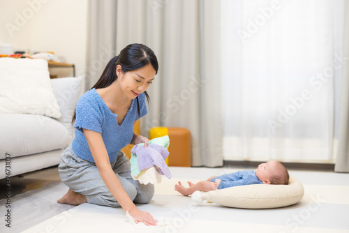 Obraz na płótnie Mum tidying playpen with baby at home in morning w salonie