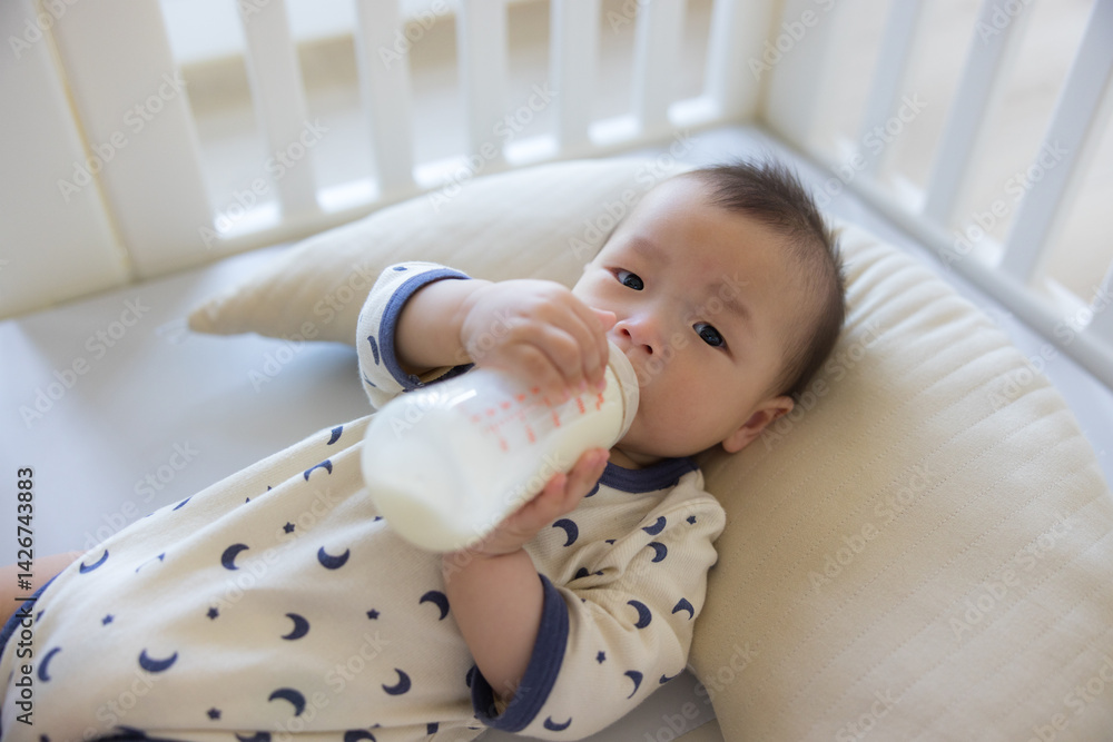 Newborn drinking formula milk from bottle