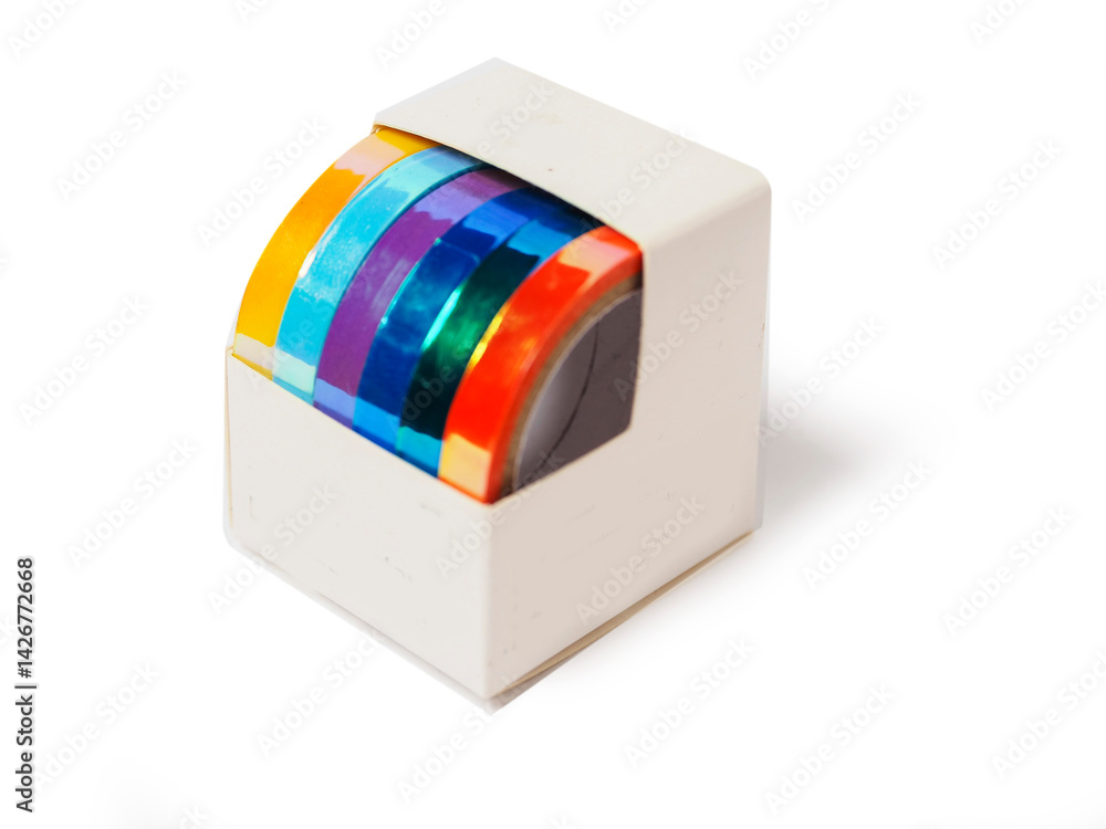 A box of colorful tape for gift wrapping is sitting on a white background. The tape has glamour shine and in a variety of colors including blue, green, yellow, and purple.