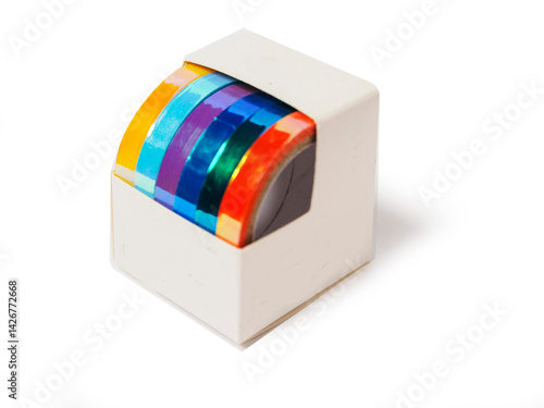 Obraz na płótnie A box of colorful tape for gift wrapping is sitting on a white background. The tape has glamour shine and in a variety of colors including blue, green, yellow, and purple. w salonie