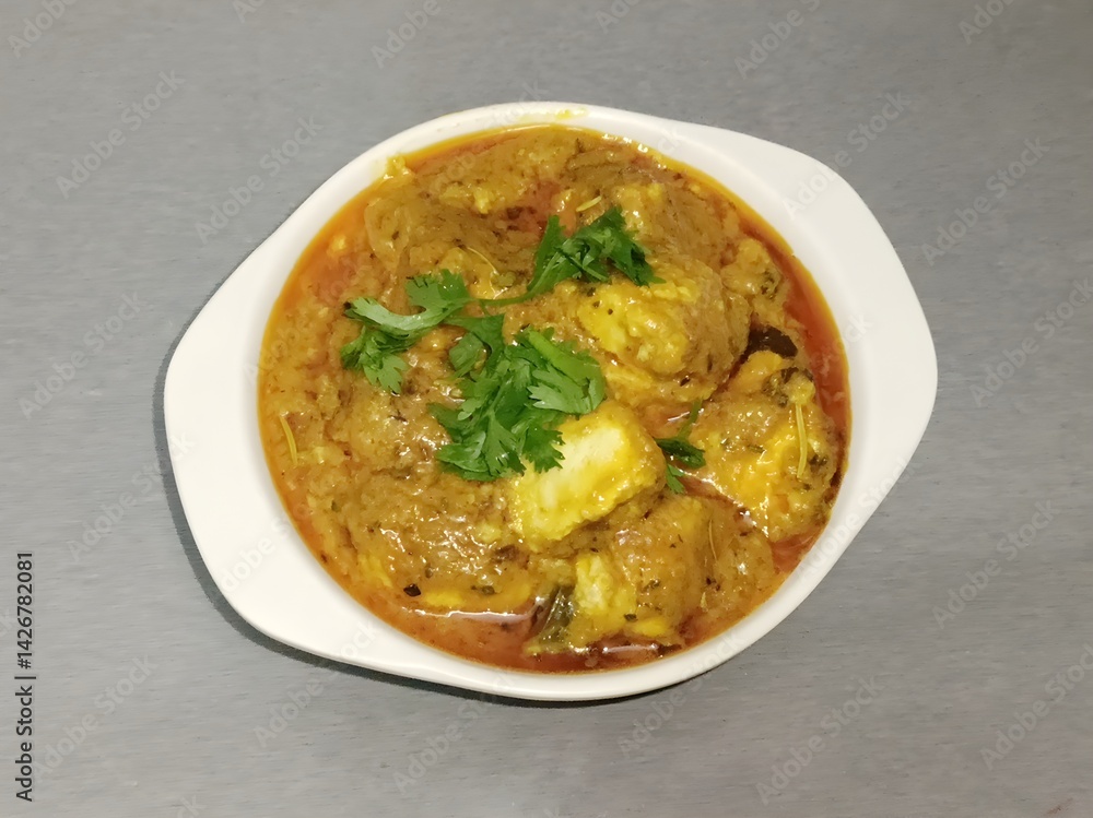 Rich paneer curry served in a white bowl, garnished with fresh cilantro. The creamy texture and vibrant spices make this a delicious and comforting Indian vegetarian favorite. Rich paneer curry served in a white bowl, garnished with fresh cilantro. The creamy texture and vibrant spices make this a delicious and comforting Indian vegetarian favorite.