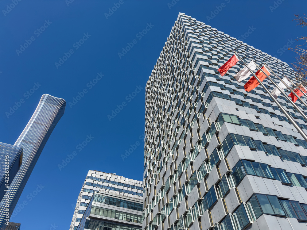 Beijing city high rise buildings and flags waving, blue sky, China. Central Business District skyscrapers