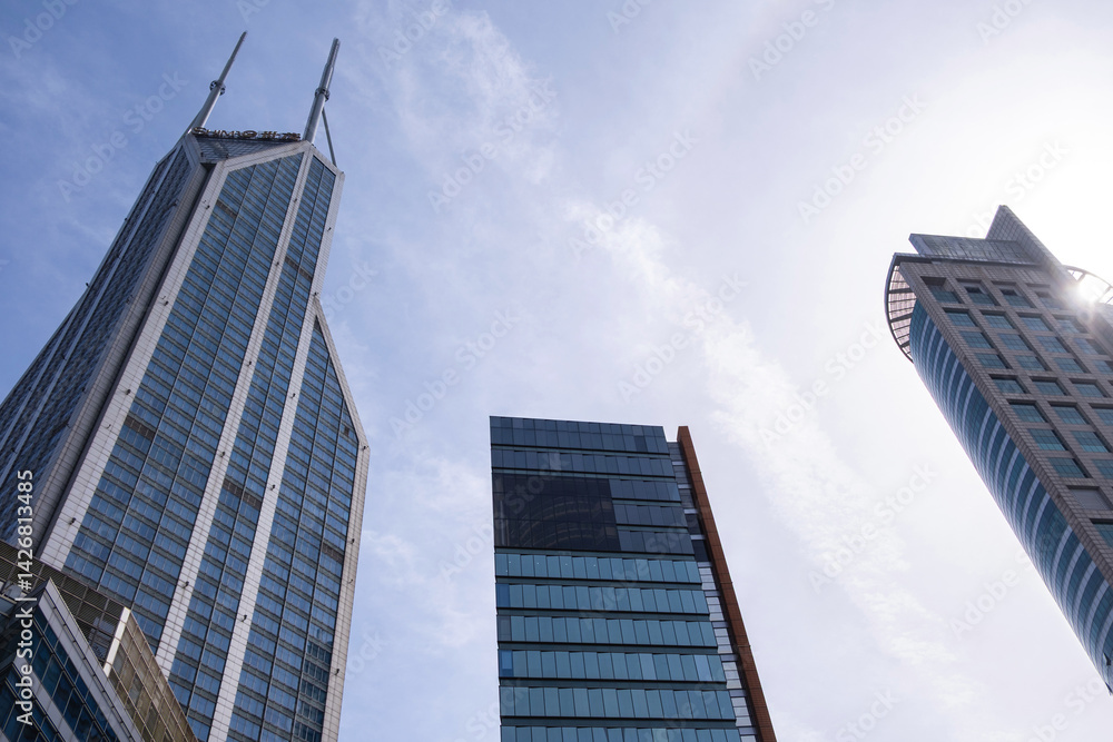 Shanghai city buildings against blue cloudy sky, High rise business offices, low angle