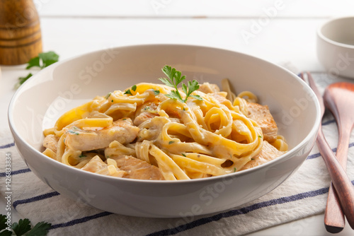 Fotografía alfredo chicken pasta,Alfredo sauce with cooked fettuccine pasta in creamy sauce and juicy chicken in white plate