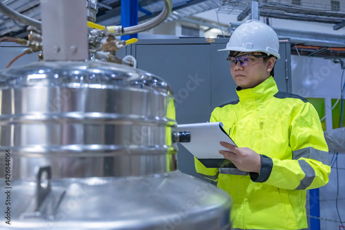 Obraz na płótnie Asian engineer working at Operating hall,Thailand people wear helmet work,He worked with diligence and patience,she checked the valve regulator at the hydrogen tank. w salonie