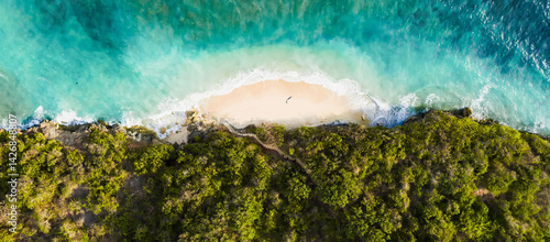 Aerial view of Green Bowl Beach in Bali, Indonesia, with turquoise waves, golden sand, and tropical jungle surrounding a hidden cove.