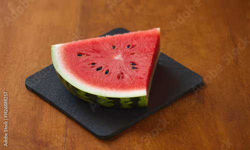 Obraz na płótnie Fresh watermelon slice served on a dark plate, perfect for a summer snack or photography prop w salonie