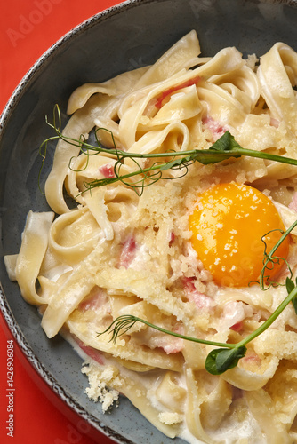 Obraz na płótnie Creamy pasta carbonara with egg yolk and pea shoots garnish w salonie