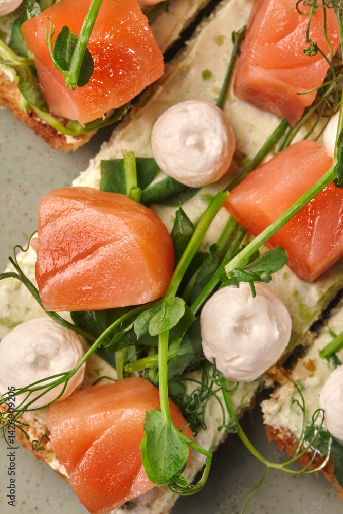 Delicious bruschetta with salmon, cream cheese and microgreens being prepared