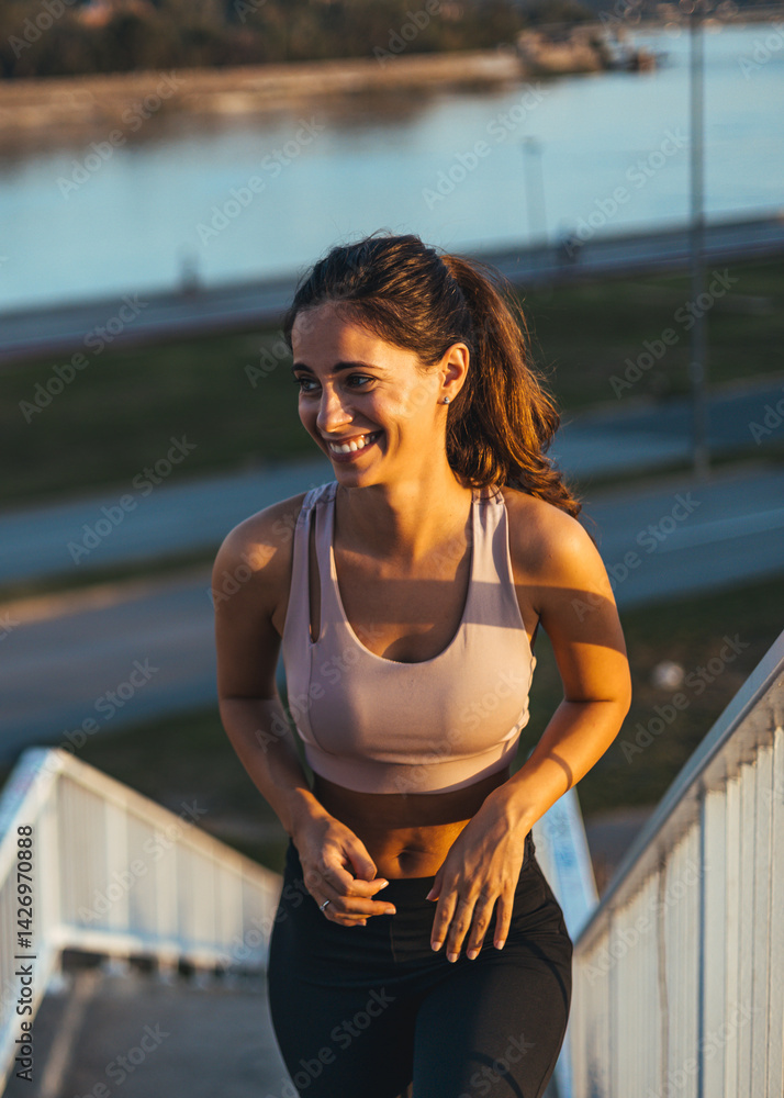 Smiling Woman Jogging Outdoors Near River During Sunset