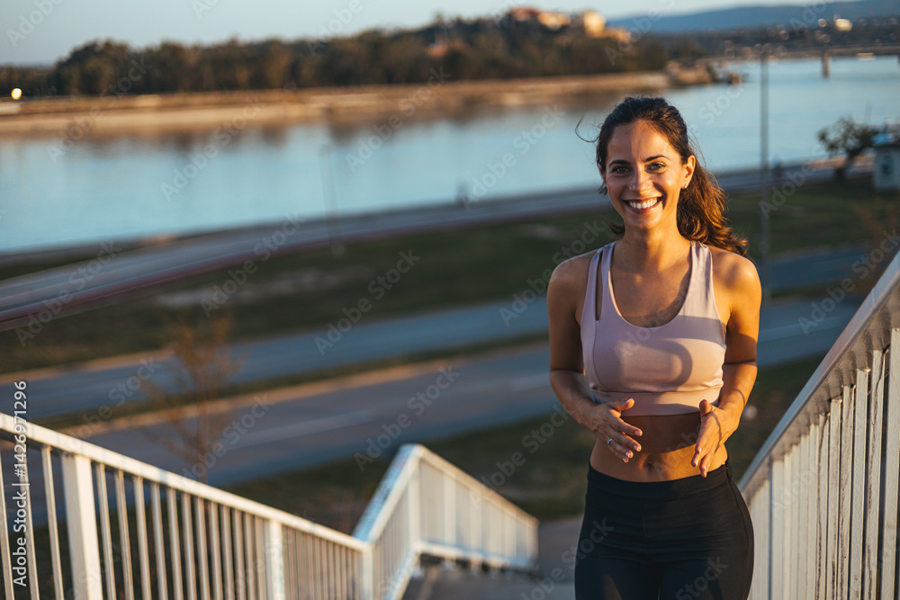 Smiling Woman on Urban Stairway Enjoying Sunset After Exercise Outdoors