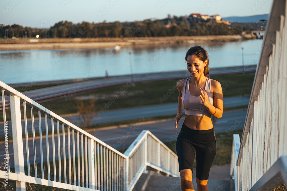 Woman Jogging Up Stairs Outdoors Near Scenic Riverbank at Sunrise