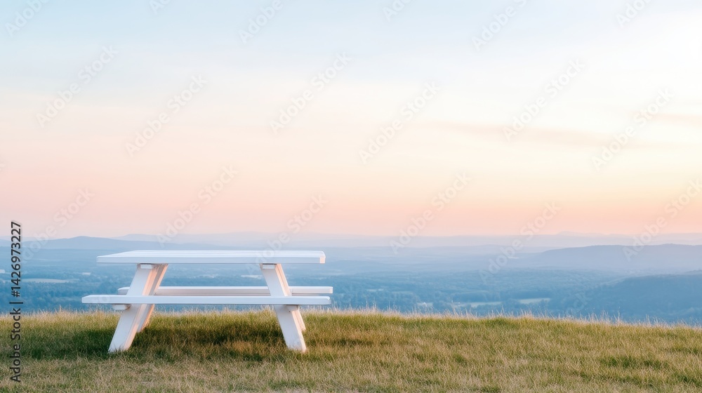 White picnic table on grassy hilltop at sunset White picnic table on grassy hilltop at sunset