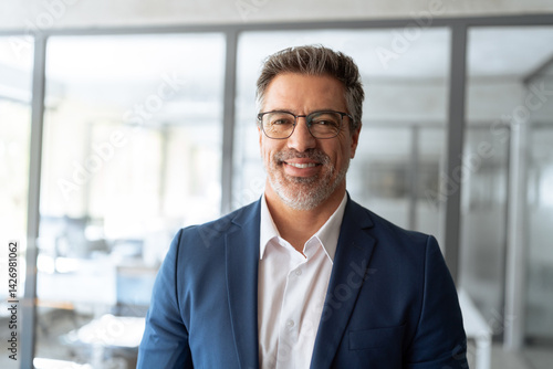 Closeup headshot portrait of indian or latin hispanic mature middle age leader, ceo male businessman in suit in office workplace. Executive confident senior business man specialist smiling at camera