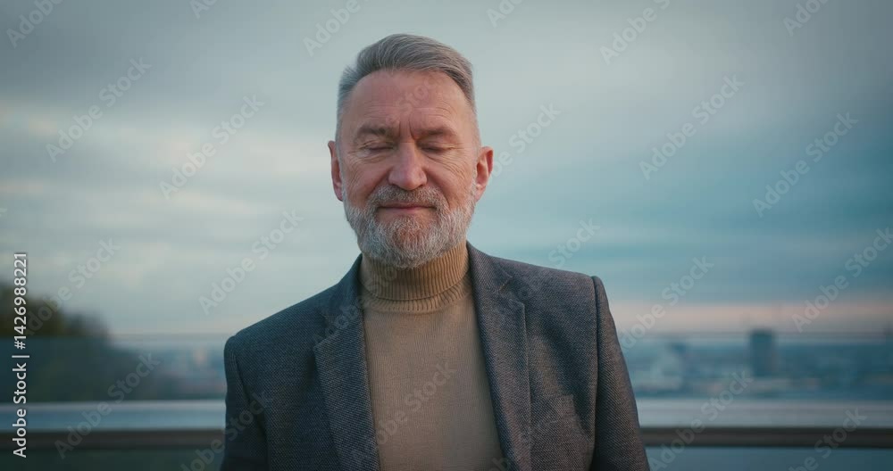 Senior Man Looking at Camera while Staying at Foorbridge at Sunrise. Mature Retired Pensioner at City in the Morning. Healthy Lifestyle Healthcare Senior Man Looking at Camera while Staying at Foorbridge at Sunrise. Mature Retired Pensioner at City in the Morning. Healthy Lifestyle Healthcare