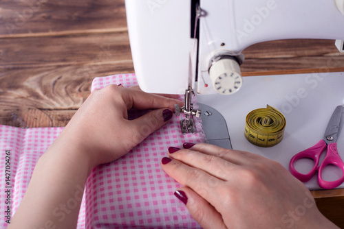 woman hand with dress at sewing machine