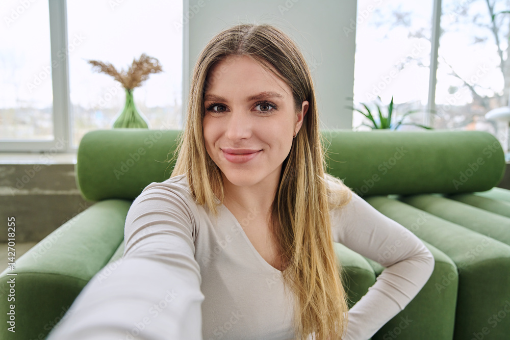 Selfie portrait happy beautiful young woman in home interior