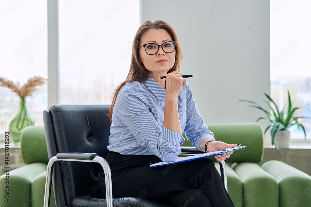 Portrait of professional psychologist therapist woman with clipboard in office