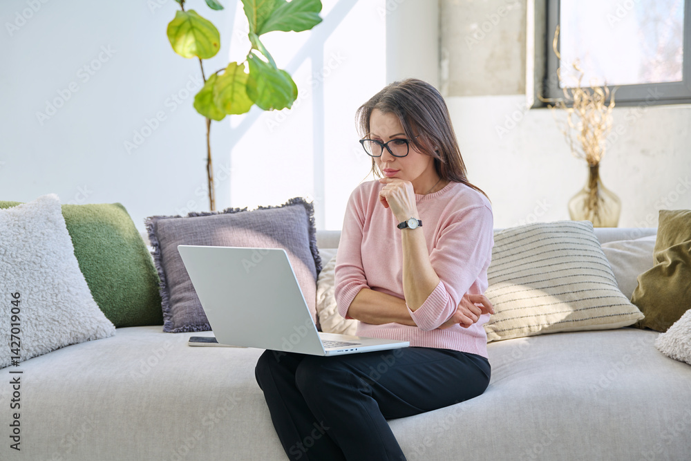 Middle aged woman working remotely, video conference, using laptop