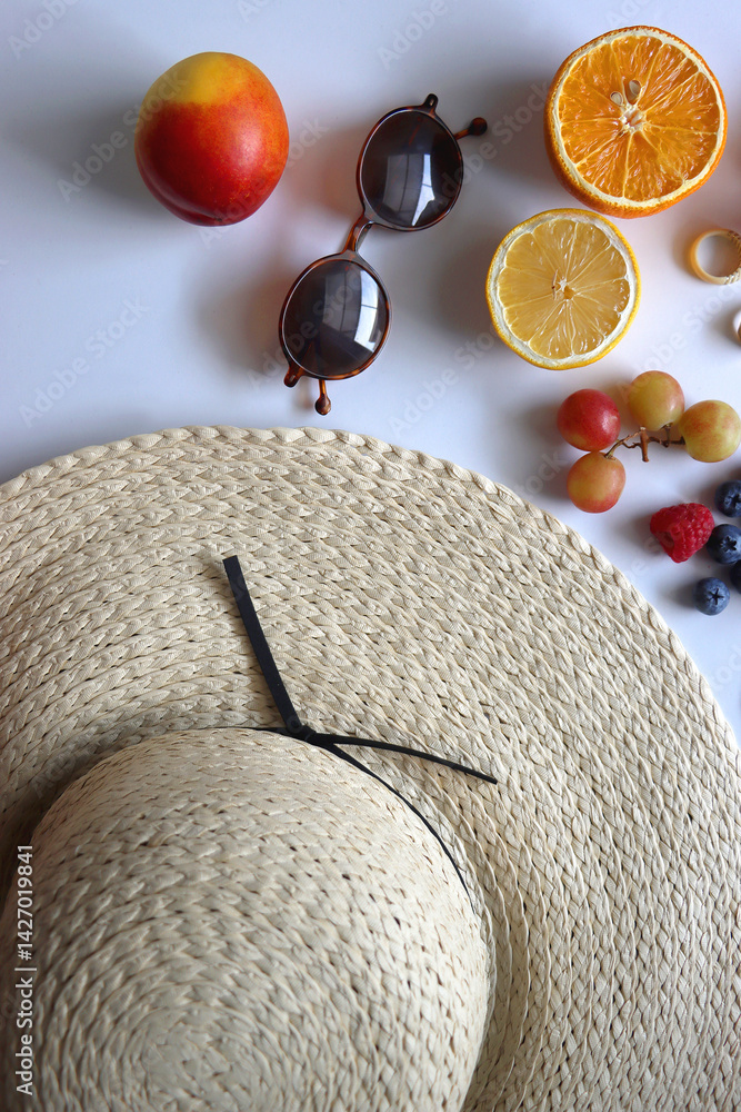 Straw hat, sunglasses, seasonal fruit, seashells and colorful accessories on white backgrounds. Cute summer essentials. Flat lay.