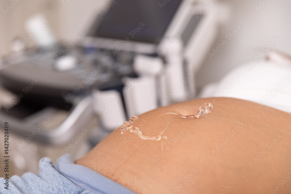 Gel on the abdomen of a pregnant woman for ultrasound medical examination in the clinic. Close up shot. High quality photo.