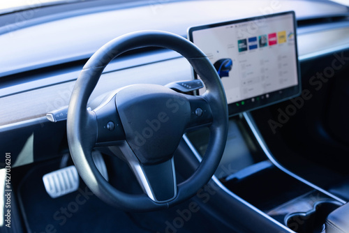 Steering wheel of electric vehicle, interior, cockpit, electric buttons. Autonomous car. Driverless car. Self-driving vehicle. Empty cockpit electric vehicle, Head Up Display and digital speedometer