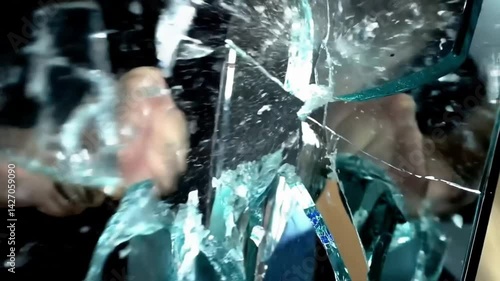 Broken mirror - A dramatic slow-motion sequence of a fist punching through a full-length mirror  