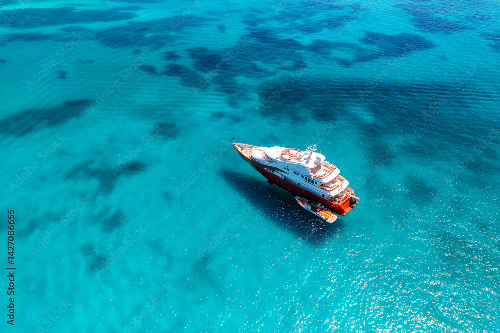 Naklejka premium Aerial view of beautiful luxury yacht and boat in blue sea in summer. Sardinia, Italy. Top drone view of speed boat, sea bay, transparent turquoise water. Travel. Tropical colorful landscape. Yachting