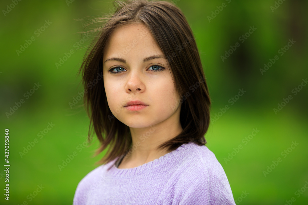 Portrait of preteen girl in park in spring.