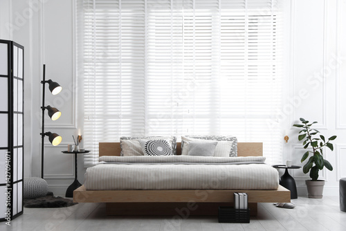 Lamp near bed in stylish room. Interior design