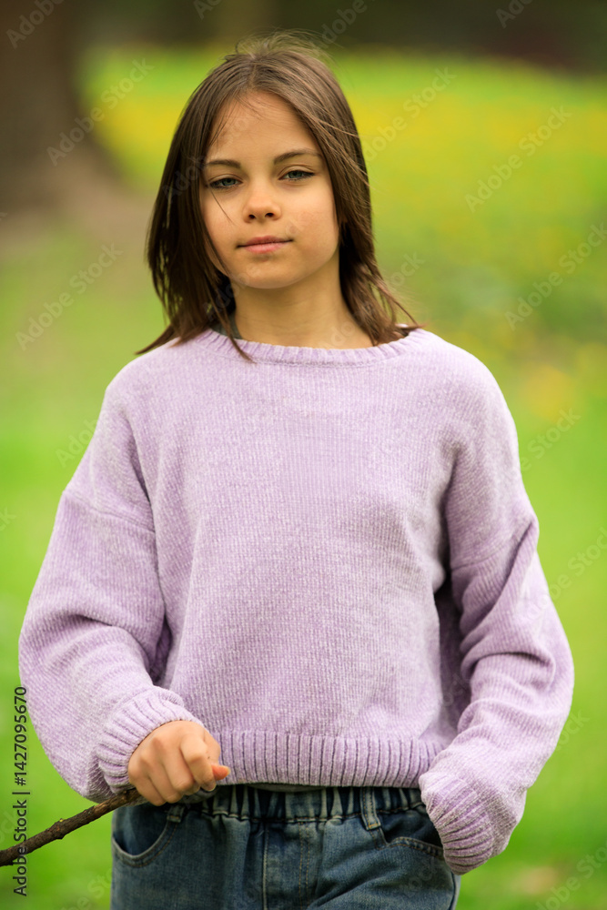 Portrait of preteen girl in park in spring.
