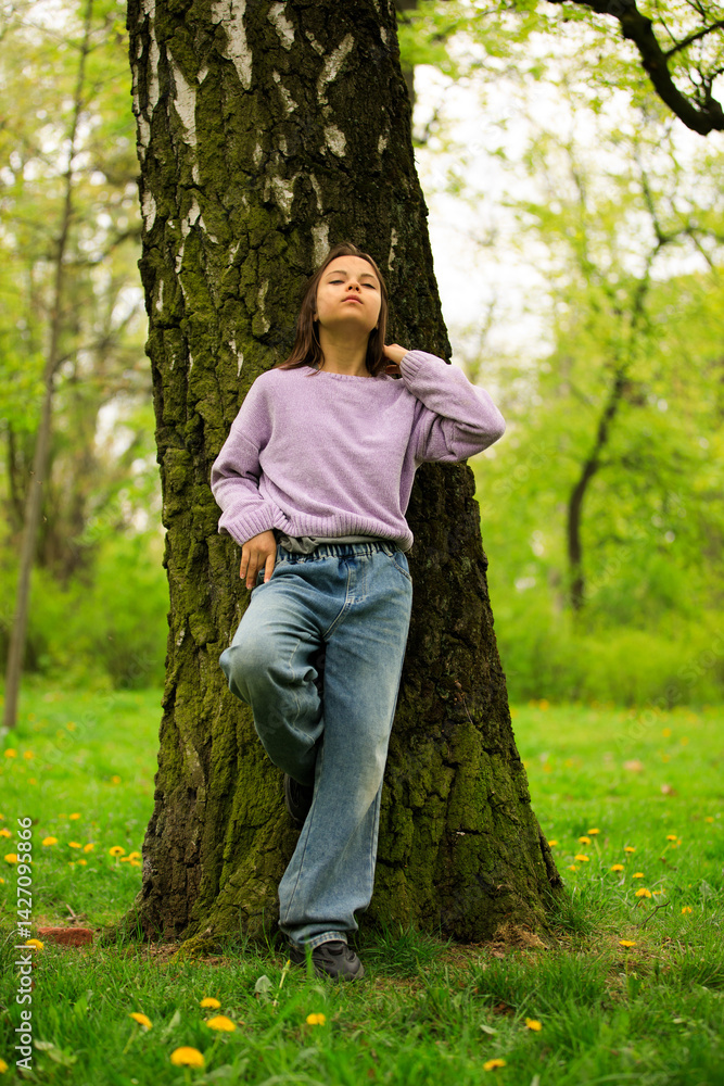 Portrait of preteen girl in park in spring.