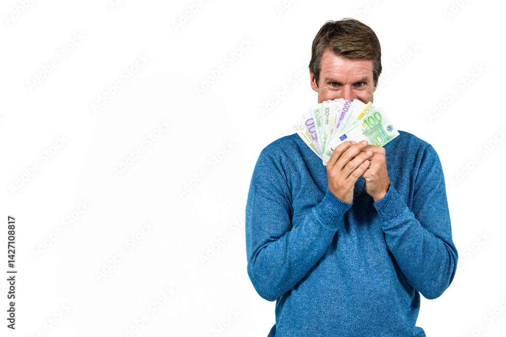 Man holding euro banknotes over face in studio, showing playful expression, copy space