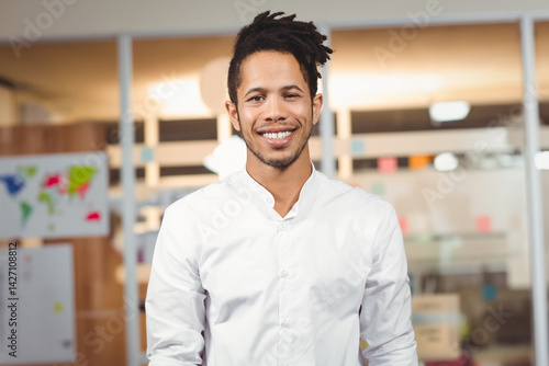 Obraz na płótnie African American man standing and smiling in office with glass partitions and colorful sticky notes w salonie