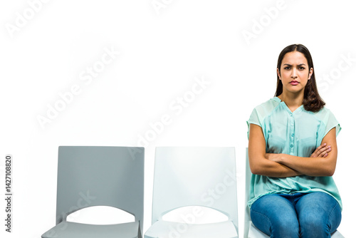 Obraz na płótnie Woman sitting on plastic chairs in empty studio, crossing arms, legs with stern look, copy space w salonie