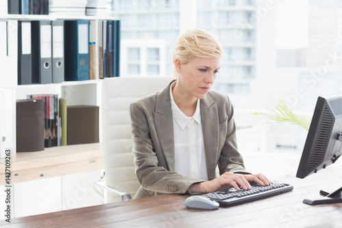 Obraz na płótnie bi-racial woman typing on keyboard at office desk with computer monitor, plant w salonie