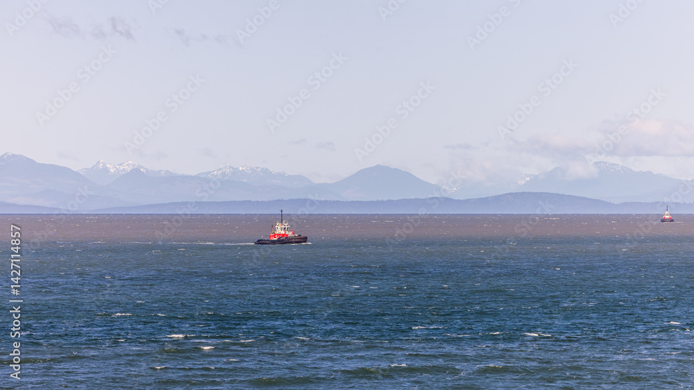 Obraz premium Red Tugboat in Coastal Waters with Mountains in the Background