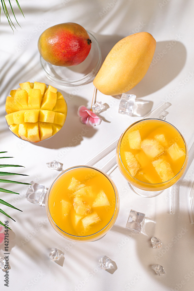 Frozen lemonade cocktail or juice with mango slices, mojito with tequila, lemon, ice, bar and party concept, restaurant and cafe advertising card, top view, selective focus. Frozen lemonade cocktail or juice with mango slices, mojito with tequila, lemon, ice, bar and party concept, restaurant and cafe advertising card, top view, selective focus.