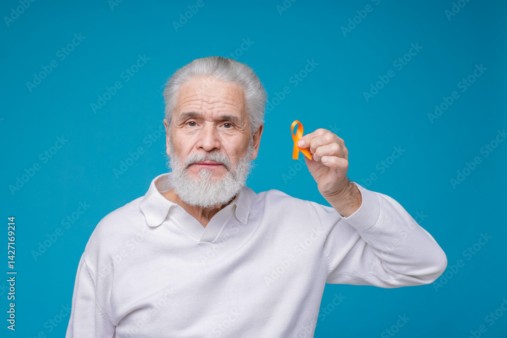 Multiple Sclerosis awareness. Senior man with orange ribbon on light blue background