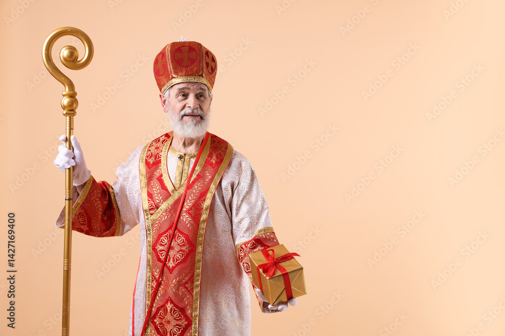 Fototapeta premium Saint Nicholas with gift on beige background. Space for text